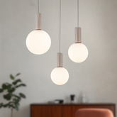 Lampe suspendue Testa beige triple globes blancs au dessus de table